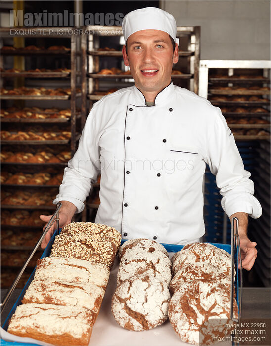 Stock photo of Baker with a Freshly Baked Breads on a Tray Buy commercial use license at MaximImages