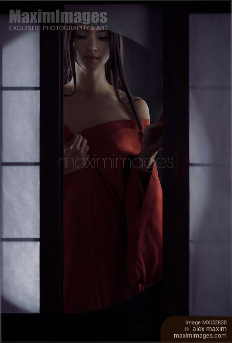 Beautiful Asian woman in undone red kimono standing by an open shoji window of a traditional Japanese house Dramatic sensual fine art portrait Stock photo of Beautiful Asian woman in undone red kimono standing by an open shoji window of a traditional Japanese house Dramatic sensual fine art portrait Buy commercial use license at MaximImages