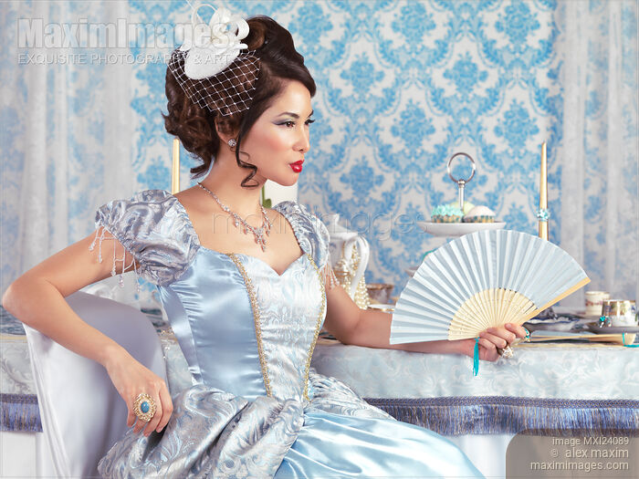 Beautiful asian woman sitting with a fan Stock photo of Beautiful asian woman sitting with a fan Buy commercial use license at MaximImages