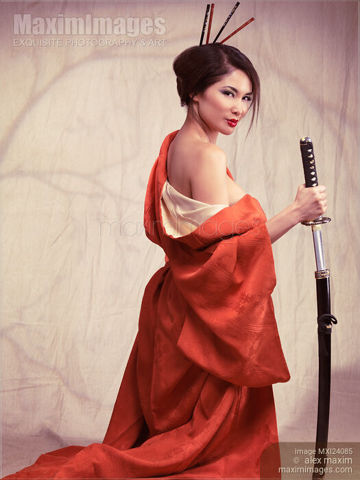 Stock photo of Beautiful asian woman unsheathing a sword Buy commercial use license at MaximImages
