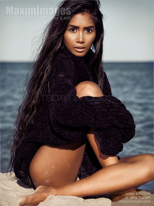Beautiful asian woman with long black hair at the beach wearing a sweater Stock photo of Beautiful asian woman with long black hair at the beach wearing a sweater Buy commercial use license at MaximImages