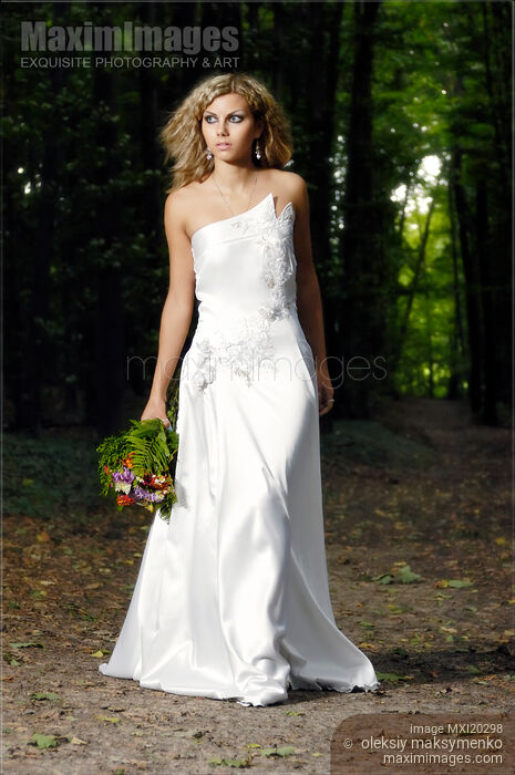 Stock photo of Beautiful Bride in Wedding Dress Walking Through the Woods Buy commercial use license at MaximImages