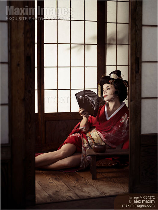 Beautiful caucasian lady, Japanese geisha sitting with hand fan in a sensual pose with her legs bared Stock photo of Beautiful caucasian lady, Japanese geisha sitting with hand fan in a sensual pose with her legs bared Buy commercial use license at MaximImages