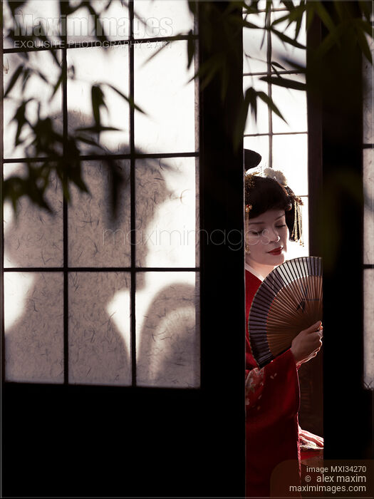 Beautiful caucasian lady, Japanese geisha with hand fan behind shoji screen of traditional Japanese house Stock photo of Beautiful caucasian lady, Japanese geisha with hand fan behind shoji screen of traditional Japanese house Buy commercial use license at MaximImages