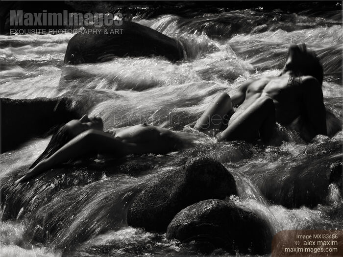 Stock photo of Beautiful nude couple making love in wild water of a mountain river in dramatic black and white nature scenery Buy commercial use license at MaximImages