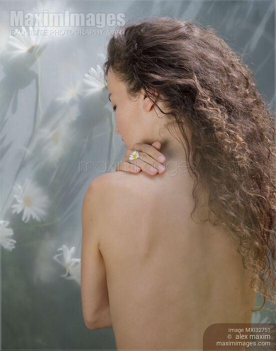 Beautiful nude woman bare back with long brown hair and a flower in her fingers in natural sunlight Stock photo of Beautiful nude woman bare back with long brown hair and a flower in her fingers in natural sunlight Buy commercial use license at MaximImages