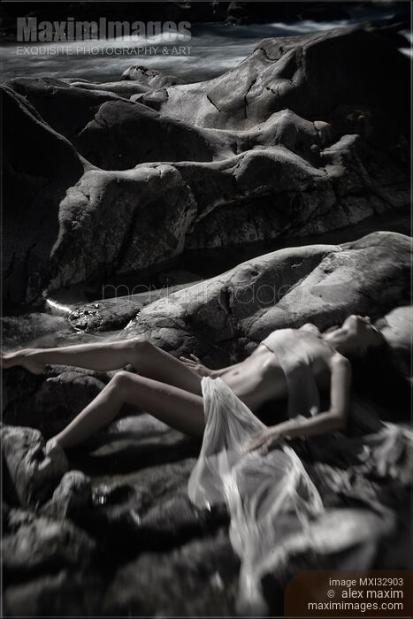 Beautiful nude woman lying by a river her naked body blending with rocky landscape Black and white fine art nudes Stock photo of Beautiful nude woman lying by a river her naked body blending with rocky landscape Black and white fine art nudes Buy commercial use license at MaximImages