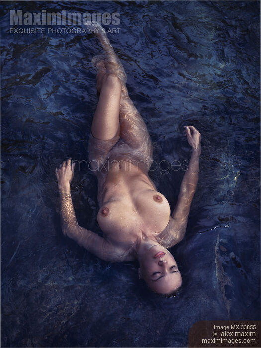 Beautiful nude woman lying in dark water relaxed with closed eyes view from above Stock photo of Beautiful nude woman lying in dark water relaxed with closed eyes view from above Buy commercial use license at MaximImages