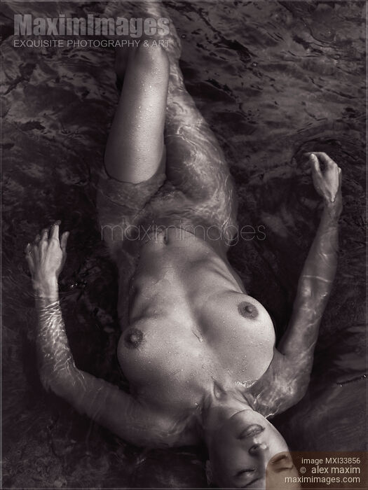 Beautiful nude woman lying in dark water relaxed with closed eyes view from above Black and white Stock photo of Beautiful nude woman lying in dark water relaxed with closed eyes view from above Black and white Buy commercial use license at MaximImages
