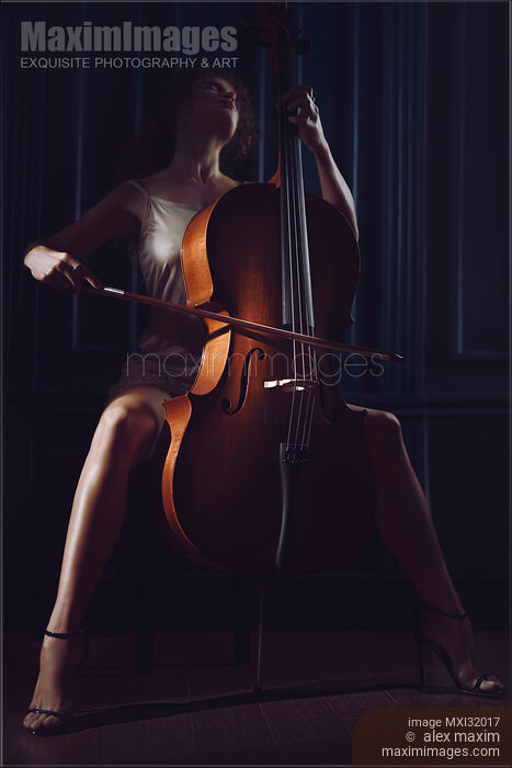 Stock photo of Beautiful sensual woman passionately playing cello in dim dramatic night time settings Buy commercial use license at MaximImages