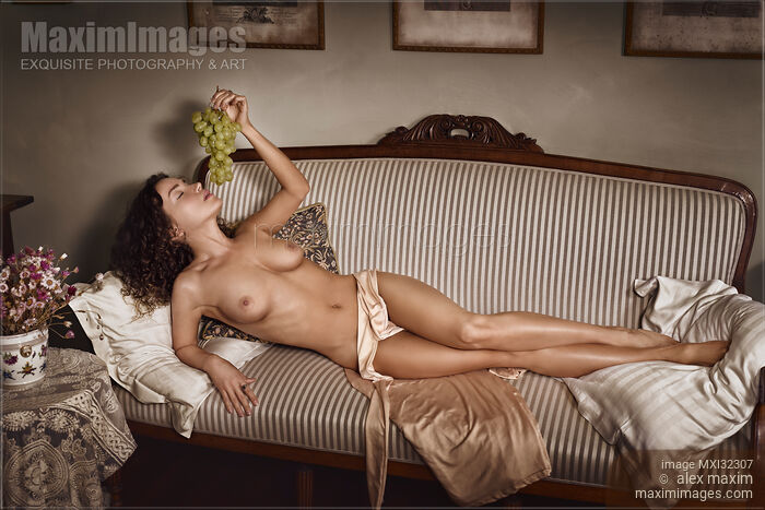 Beautiful sexy nude woman lying on a couch naked with grapes in her hand French boudoir artistic portrait Stock photo of Beautiful sexy nude woman lying on a couch naked with grapes in her hand French boudoir artistic portrait Buy commercial use license at MaximImages