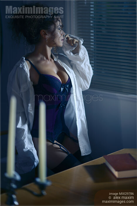 Beautiful sexy woman in a men's shirt on top of a corset sitting by the window at night Stock photo of Beautiful sexy woman in a men's shirt on top of a corset sitting by the window at night Buy commercial use license at MaximImages