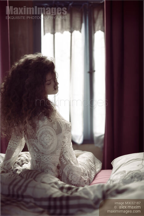 Beautiful sexy woman sitting in bed just awaken wearing sheer nightgown in morning light Stock photo of Beautiful sexy woman sitting in bed just awaken wearing sheer nightgown in morning light Buy commercial use license at MaximImages