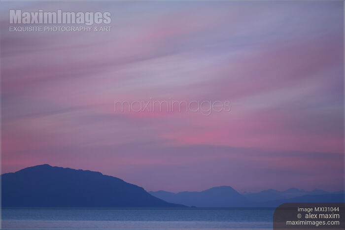 Stock photo of Beautiful surreal twilight sky in pink and lavender pastel colors scenery above mountains of British Columbia coast Buy commercial use license at MaximImages
