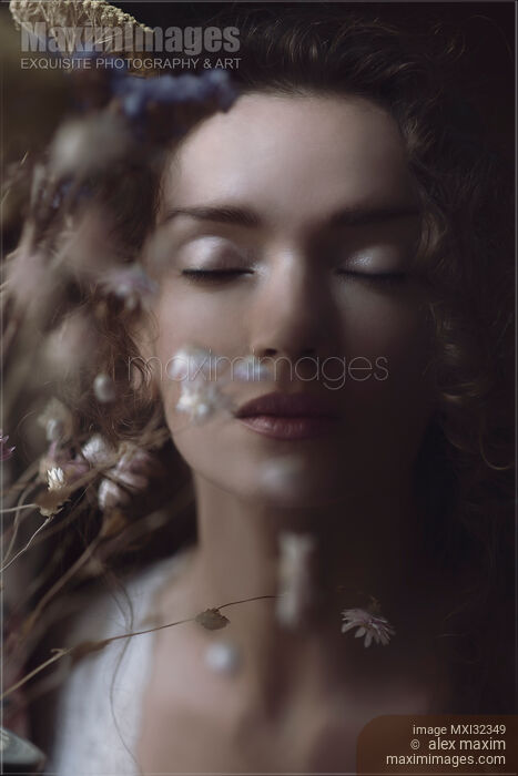 Beautiful tranquil woman face with closed eyes behind wild flowers dreamy portrait Stock photo of Beautiful tranquil woman face with closed eyes behind wild flowers dreamy portrait Buy commercial use license at MaximImages