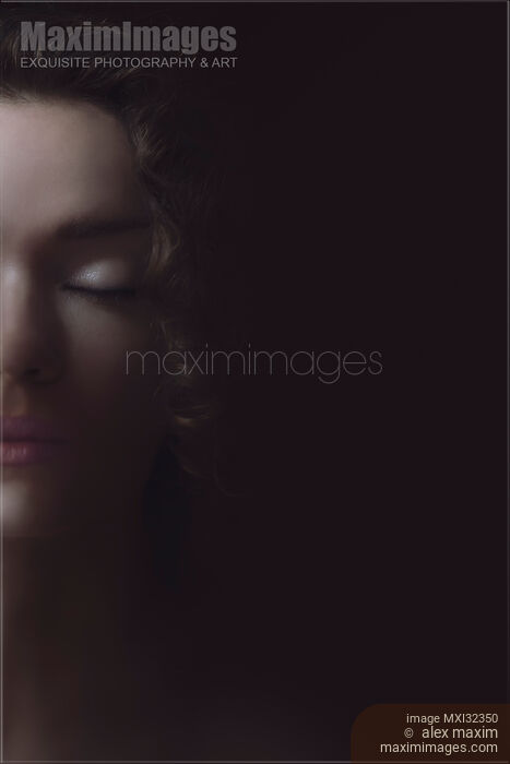 Stock photo of Beautiful tranquil woman face with closed eyes half hidden by shadows dreamy portrait Buy commercial use license at MaximImages