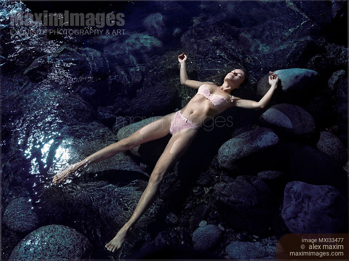 Beautiful woman in pink lingerie lying relaxed half-naked in calm clear water of a river. View from above. Stock photo of Beautiful woman in pink lingerie lying relaxed half-naked in calm clear water of a river. View from above. Buy commercial use license at MaximImages