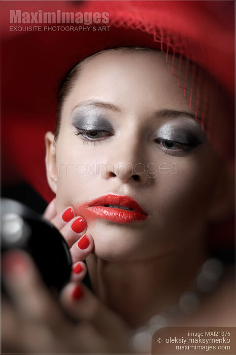 Stock photo of Beautiful Woman Smearing Lipstick Buy commercial use license at MaximImages
