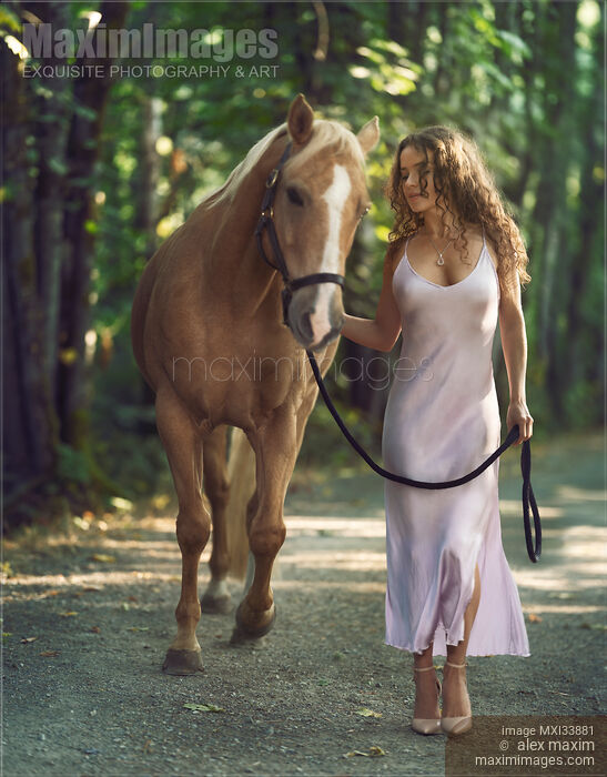 Stock photo of Beautiful woman walking with a horse along the trail in an elegant silk dress Buy commercial use license at MaximImages