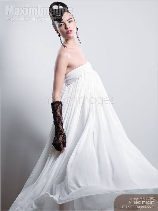 Beautiful Woman with a Creative Hairstyle Wearing a Long White Dress Stock photo of Beautiful Woman with a Creative Hairstyle Wearing a Long White Dress Buy commercial use license at MaximImages