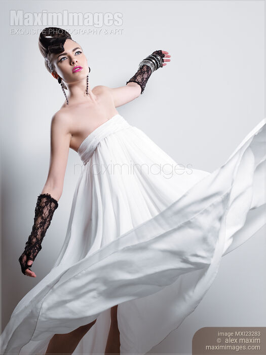 Beautiful Woman with a Creative Hairstyle Wearing a Long White Dress Stock photo of Beautiful Woman with a Creative Hairstyle Wearing a Long White Dress Buy commercial use license at MaximImages