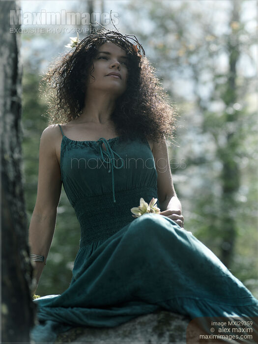 Stock photo of Beautiful woman with a wreath on her head sitting in the nature Buy commercial use license at MaximImages