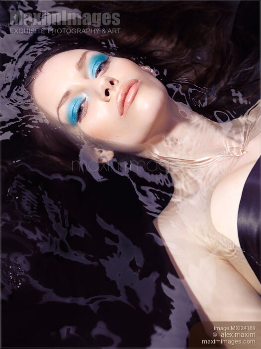 Beautiful woman with blue makeup lying in water Stock photo of Beautiful woman with blue makeup lying in water Buy commercial use license at MaximImages
