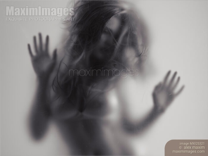 Stock photo of Beautiful young woman behind glass Buy commercial use license at MaximImages