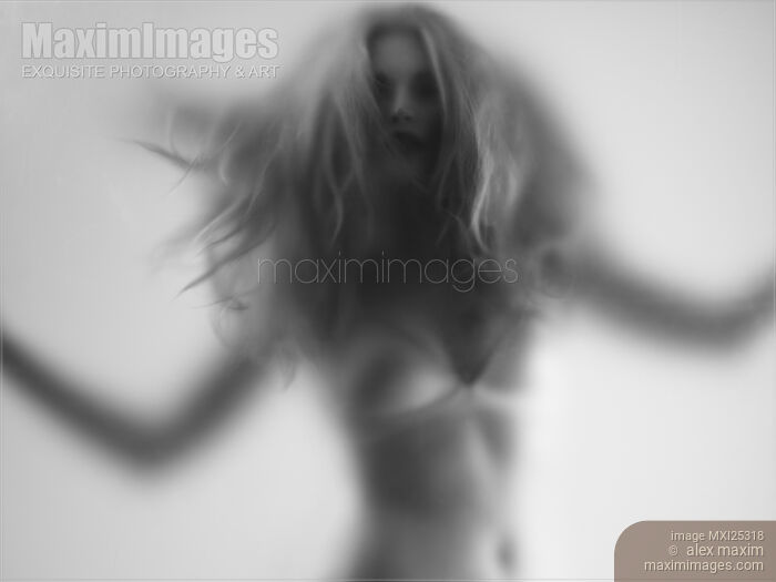 Beautiful young woman behind hazy glass Stock photo of Beautiful young woman behind hazy glass Buy commercial use license at MaximImages