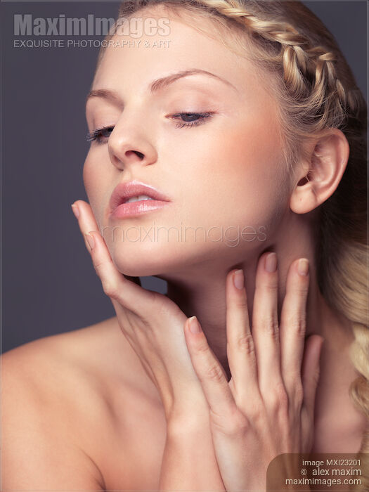 Stock photo of Beautiful young woman touching her face with natural light makeup Buy commercial use license at MaximImages