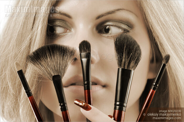Stock photo of Beautiful Young Woman with Make-up Brushes Buy commercial use license at MaximImages