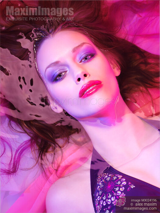 Beauty face portrait of woman lying in water with makeup in vivid pink colors Stock photo of Beauty face portrait of woman lying in water with makeup in vivid pink colors Buy commercial use license at MaximImages