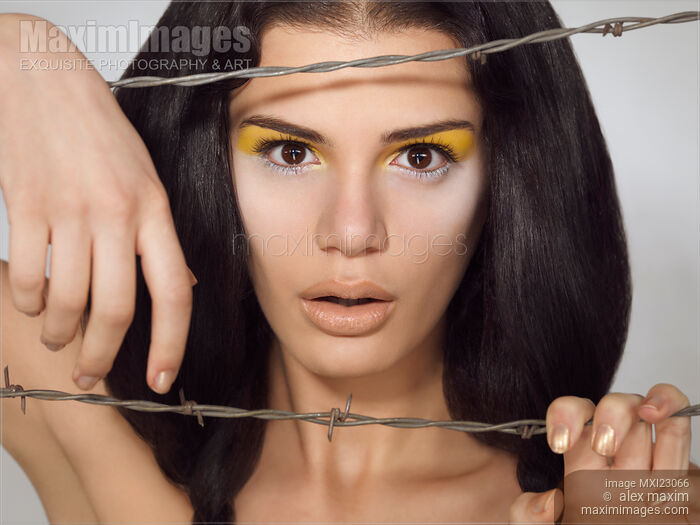 Stock photo of Beauty Portrait of a Woman Behind Barbed Wire Buy commercial use license at MaximImages