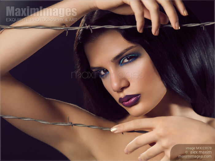 Stock photo of Beauty Portrait of a Woman Behind Barbed Wire Buy commercial use license at MaximImages