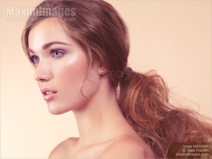 Beauty portrait of a young woman with long red hair in a ponytail Stock photo of Beauty portrait of a young woman with long red hair in a ponytail Buy commercial use license at MaximImages