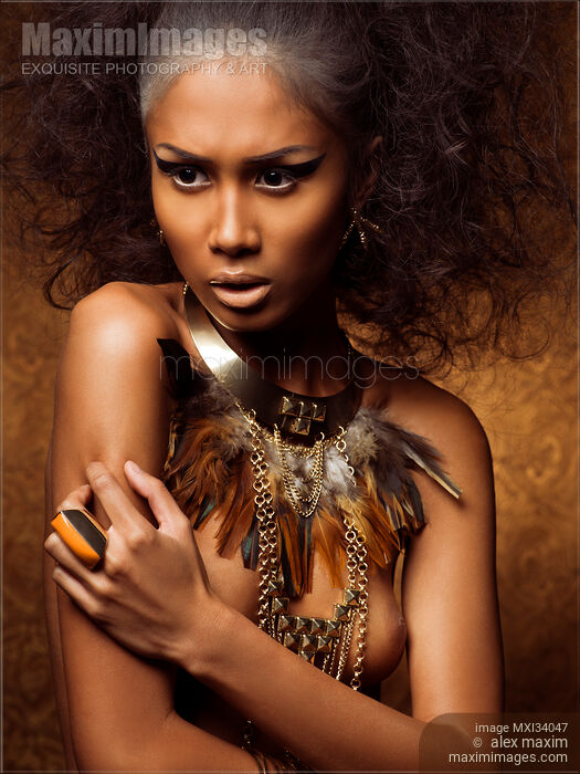 Beauty portrait of exotic native woman with tribal feather necklace over naked bronze skin and bare breasts Stock photo of Beauty portrait of exotic native woman with tribal feather necklace over naked bronze skin and bare breasts Buy commercial use license at MaximImages