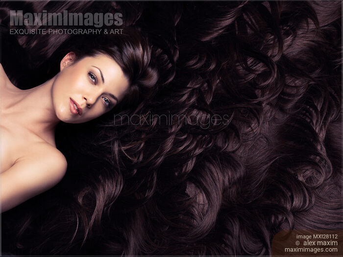 Stock photo of Beauty portrait of woman face surrounded by long luscious brown hair Buy commercial use license at MaximImages