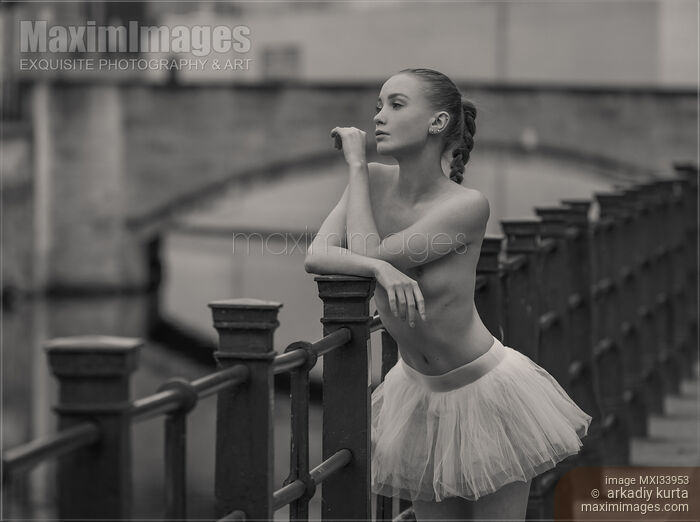 Stock photo of Black and white fine art nude portrait of a young topless woman in tutu skirt standing on a bridge Buy commercial use license at MaximImages