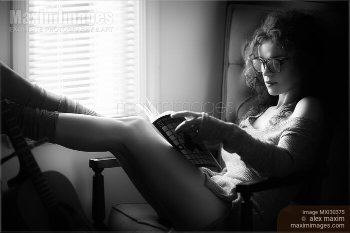 Black and white portrait of a sexy woman in large reading glasses at home with a book Stock photo of Black and white portrait of a sexy woman in large reading glasses at home with a book Buy commercial use license at MaximImages