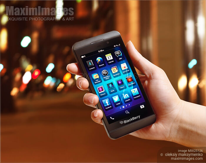 Stock photo of Blackberry Z10 smartphone in hand on street at night Buy commercial use license at MaximImages
