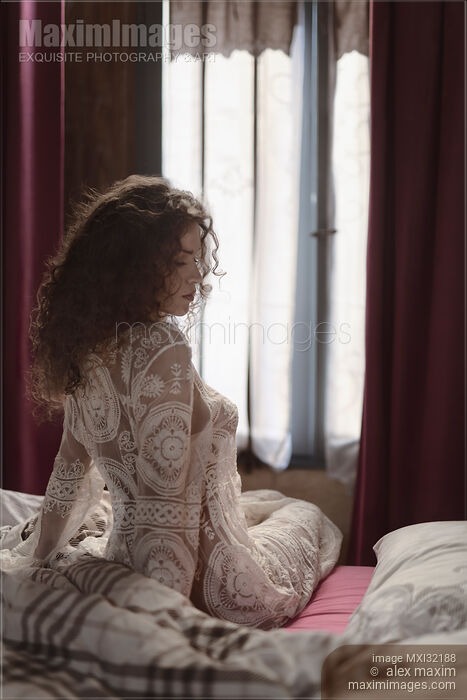 Boudoir portrait of beautiful sexy woman sitting in bed just awaken wearing sheer nightgown in morning light Stock photo of Boudoir portrait of beautiful sexy woman sitting in bed just awaken wearing sheer nightgown in morning light Buy commercial use license at MaximImages