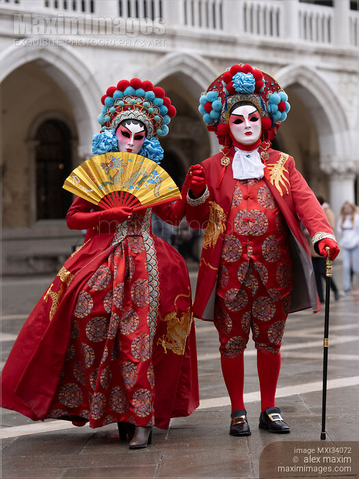 Stock photo of Brightly dressed couple in oriental red costumes and masks during the Carnival of Venice Italy Buy commercial use license at MaximImages