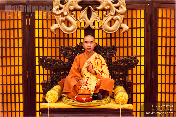 Buddhist monk meditating with wooden fish Stock photo of Buddhist monk meditating with wooden fish Buy commercial use license at MaximImages