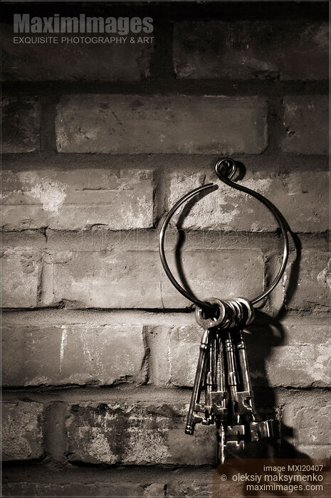 Photo of Bunch of antique keys on brick wall background black and white