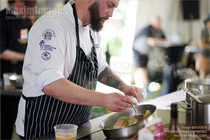 Stock photo of Chef Chris Braun preparing a gourmet competition meal at BC Seafood Festival Chef Challenge Buy commercial use license at MaximImages