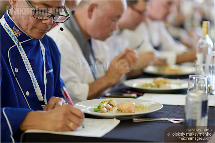 Chef competition judge making notes on a gourmet competition meal at BC Seafood Festival Stock photo of Chef competition judge making notes on a gourmet competition meal at BC Seafood Festival Buy commercial use license at MaximImages