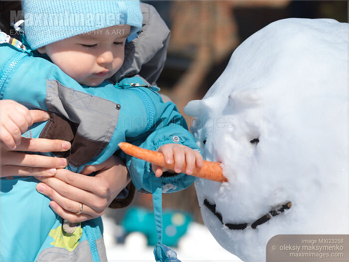 Stock photo of Child Grabbing Snowman's Nose Buy commercial use license at MaximImages
