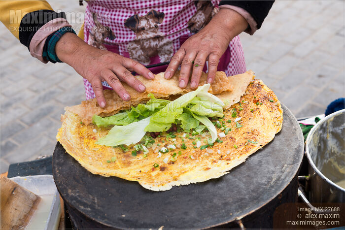 Stock photo of Chinese woman making egg rolls Buy commercial use license at MaximImages