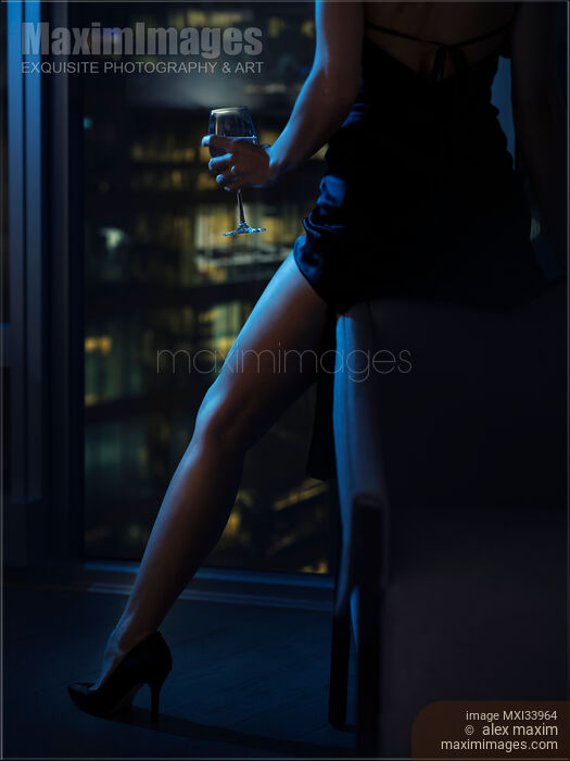 Closeup of a sexy leg in high heel shoes of a woman sitting with a glass of wine by a condo window at night Stock photo of Closeup of a sexy leg in high heel shoes of a woman sitting with a glass of wine by a condo window at night Buy commercial use license at MaximImages