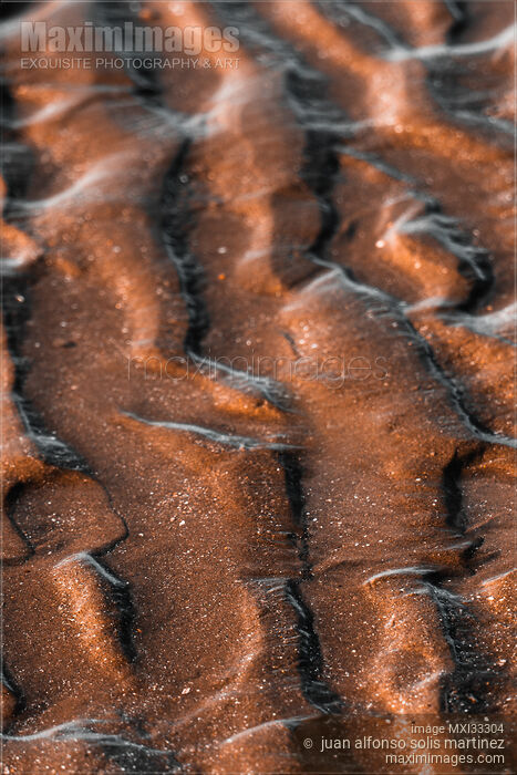 Closeup of a wave patterns background in the sea sand at low tide at sunrise Stock photo of Closeup of a wave patterns background in the sea sand at low tide at sunrise Buy commercial use license at MaximImages